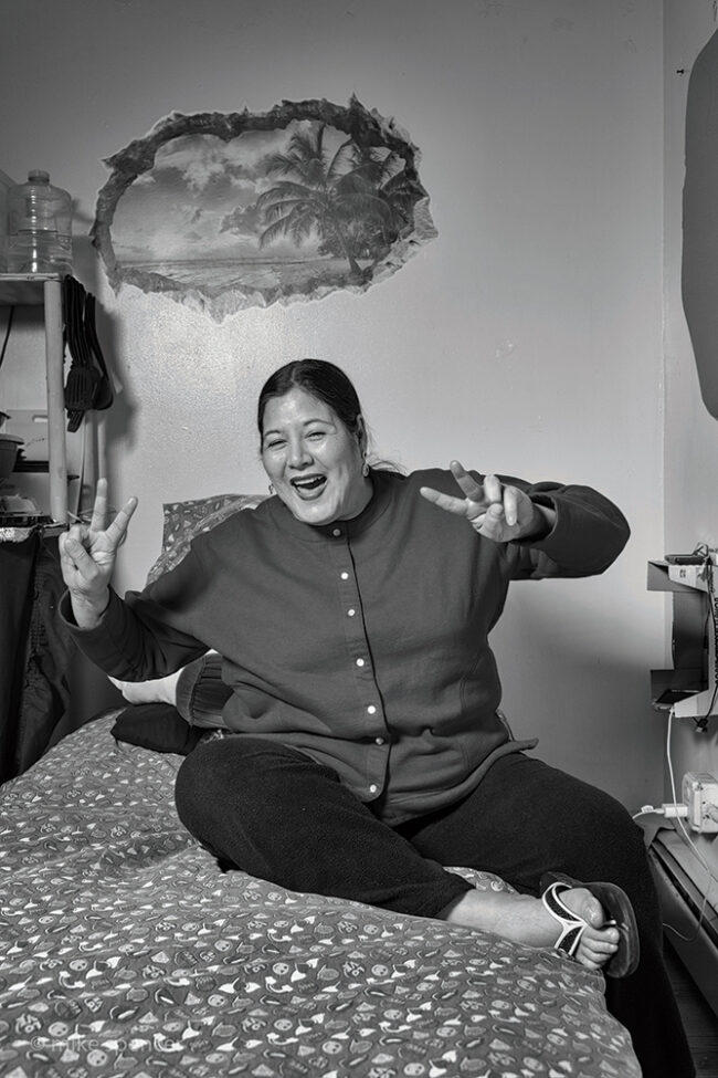 homes for hope – mhsa-19 smiling woman showing peace signs on her bed